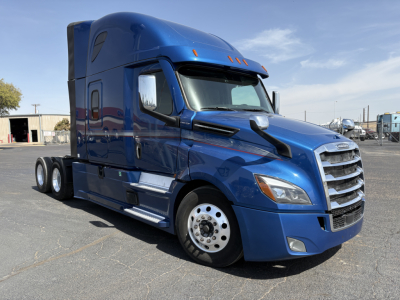 Freightliner Cascadia 126 sleeper tractor truck in blue, side view showing chrome grille and dual rear axles.