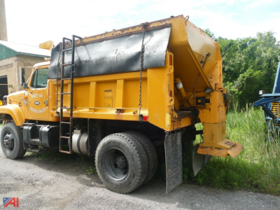 Dump truck with sander attachment showing side view and rear hopper, yellow paint, black reservoir cover, ladder, and large tires