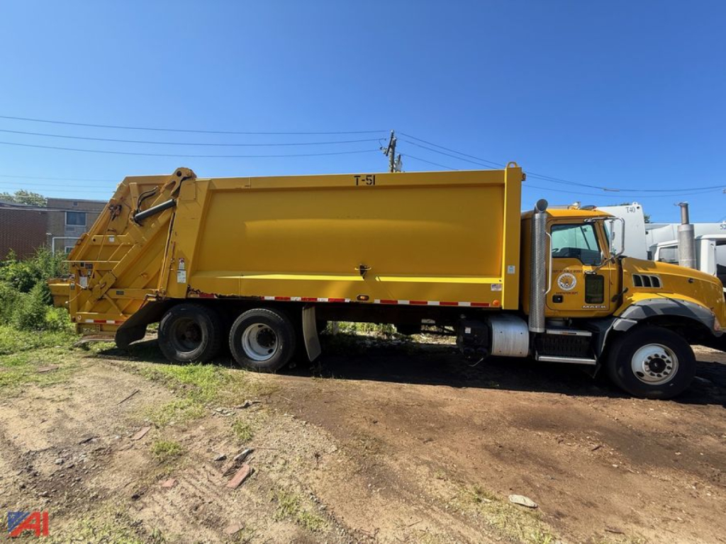 2014 Mack garbage truck side view showing large yellow refuse body and hopper with black tires