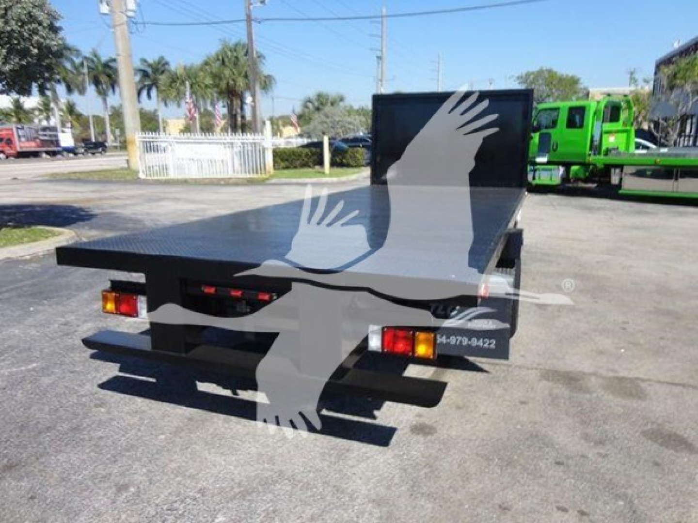 Flatbed truck bed of a used 2011 Ford E450 with rear bumper and taillights visible.