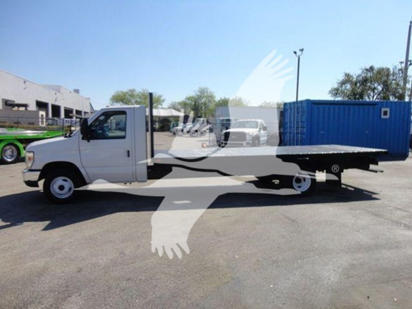 Flatbed tow truck, 2011 Ford E450, side view showing long flatbed bed and standard cab, VIN 1FDXE4FS3BDB20639 on vehicle listing.