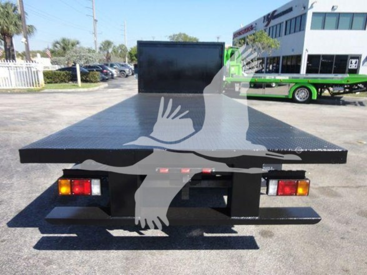 Flatbed truck bed with large aluminum platform and rear lights visible.