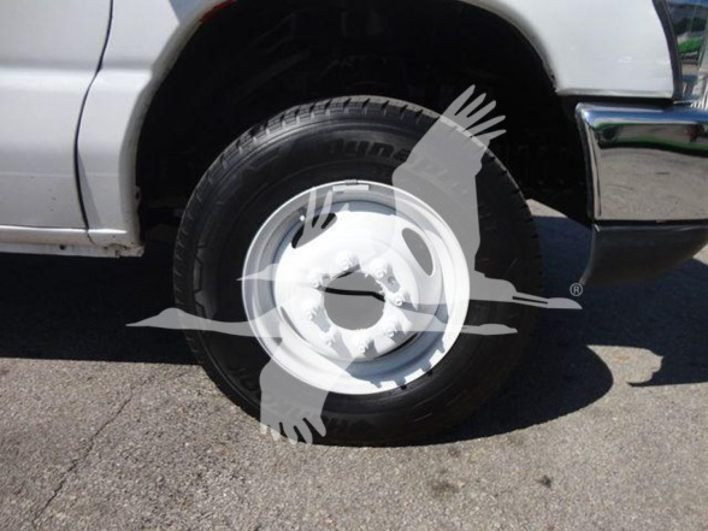 Ford E450 wheel and tire along with front fender and bumper showing a flatbed truck in serviceable condition.