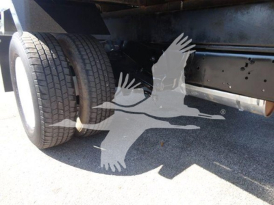 Ford E-450 chassis showing dual rear tires and undercarriage area with flatbed base visible.