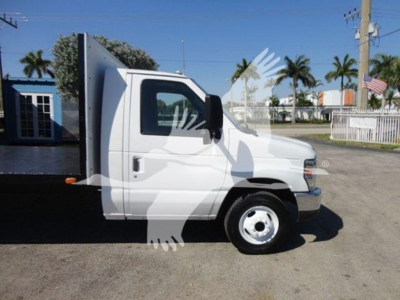 Ford E-450 cab & chassis side view showing flatbed body and white exterior.