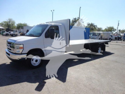 Ford E-450 flatbed truck with utility box. Visible text: no legible labels or stickers clearly readable in image. The vehicle has a white cab and flatbed with side storage compartments.