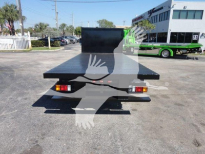 Flatbed tow truck bed on rear of a 2011 Ford E450 with tail lights and spare platform visible.