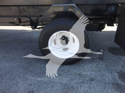 Ford E450 chassis with flatbed showing wheel and suspension components.