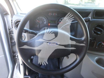 Ford E-Series dashboard and steering wheel view in a 2011 Ford E450 flatbed truck showing steering wheel and instrument cluster.