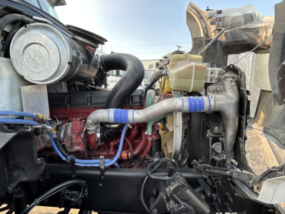 Engine bay of 2020 Mack GR64B mixer truck showing radiator, coolant reservoir, turbocharger piping, and engine components with blue hose clamps.