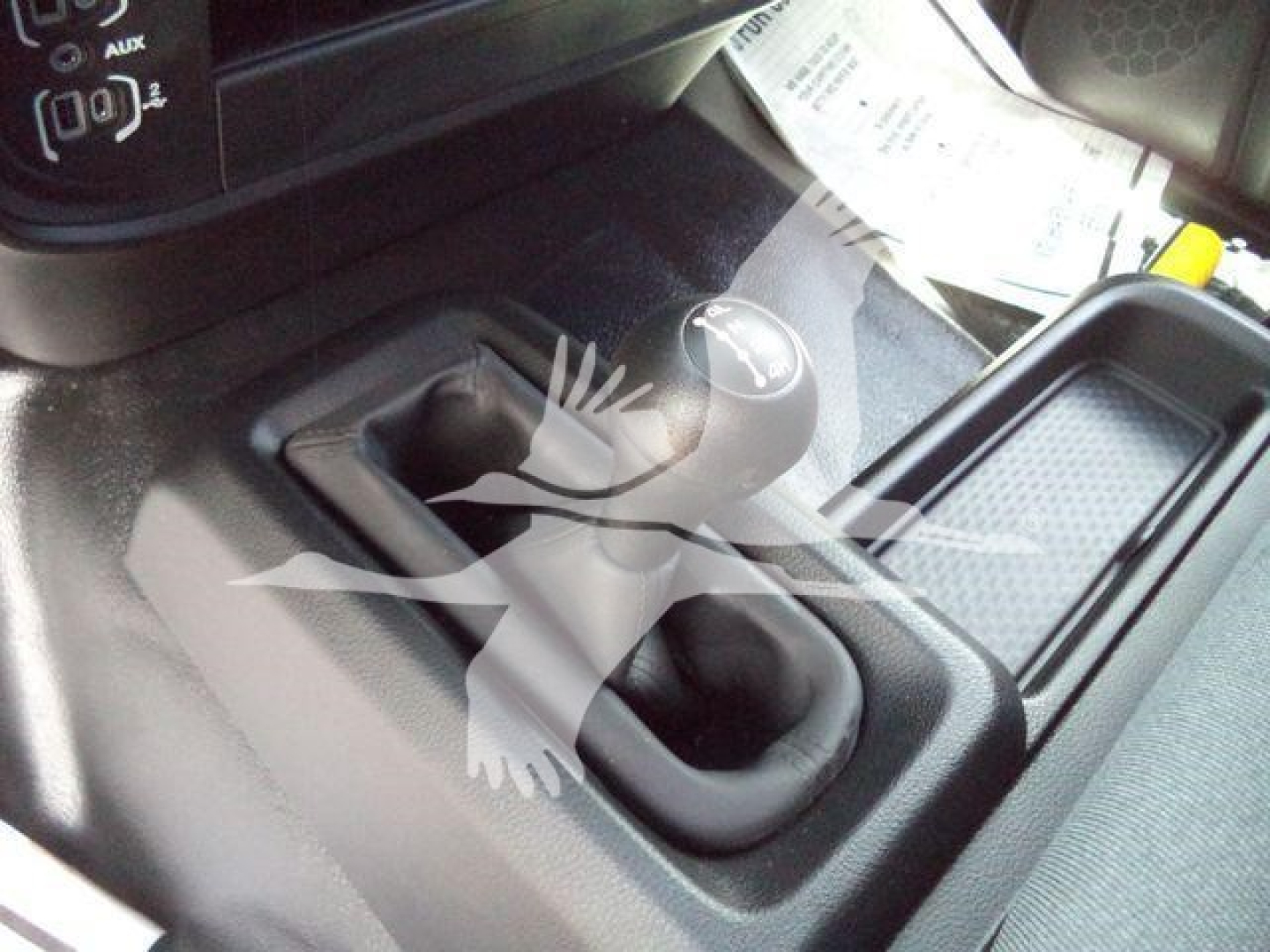 Truck interior center console with shift lever and gear selector, showing two cup holders and a surrounding storage area.