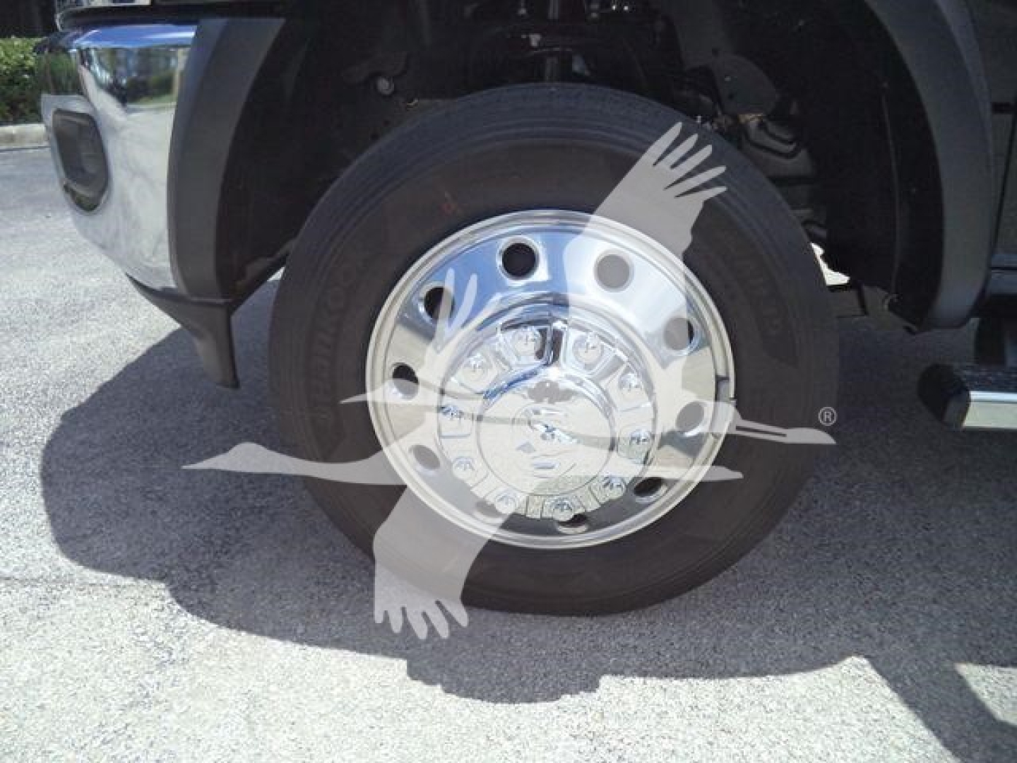 Wheel assembly of a 2024 Ram 5500 SLT showing a polished aluminum hubcap and black radial tire.