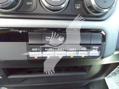 Ram 5500 dash area showing auxiliary switches labeled AUX 1, AUX 2, AUX 3, AUX 4, PTO, HIGH IDLE and a Tow/Haul panel.