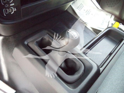 Truck interior center console with shift lever and gear selector, showing two cup holders and a surrounding storage area.