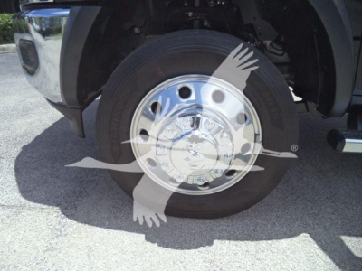 Wheel assembly of a 2024 Ram 5500 SLT showing a polished aluminum hubcap and black radial tire.