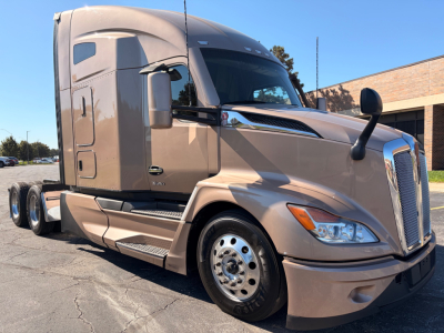 Kenworth T680 sleeper cab tractor truck in beige showing front grille, headlights, and tandem rear wheels; VIN 1XKYDP9X6PJ243739 not visible text in image.