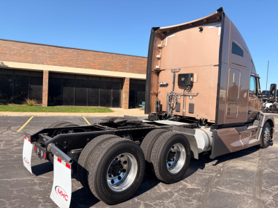 Kenworth T680 semi-truck tractor chassis rear view showing dual rear axles and fifth-wheel area, pink-beige cab, VIN 1XKYDP9X6PJ243739 on listing.