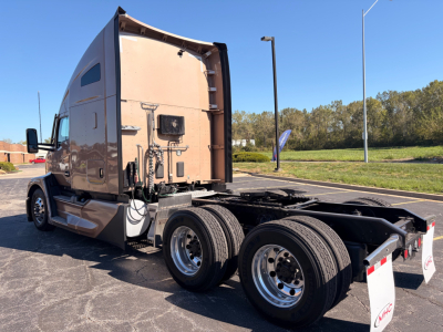 Kenworth T680 tractor rear and cab side view showing sleeper sleeper cab and dual rear axles with wheels, beige paint, and chassis.