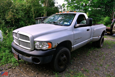 Dodge Ram 3500 pickup truck in-yard view showing front grille and extended cab with light-colored paint.