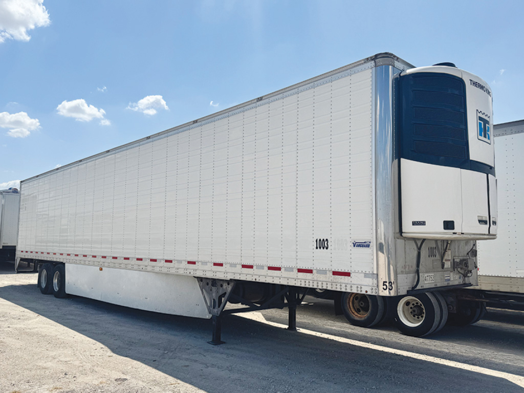 Reefer trailer in a yard showing Thermo King refrigeration unit at front and aluminum side panels; trailer is a Vanguard aluminum reefer with 53-foot length, landing gear visible, stock number 558294