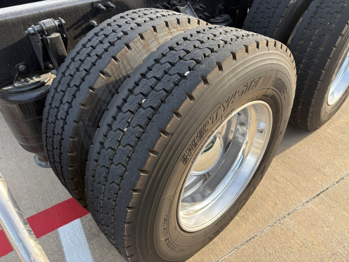 Dual rear axle tires on a Mack AN64T70 cab, with tread and sidewall details visible.