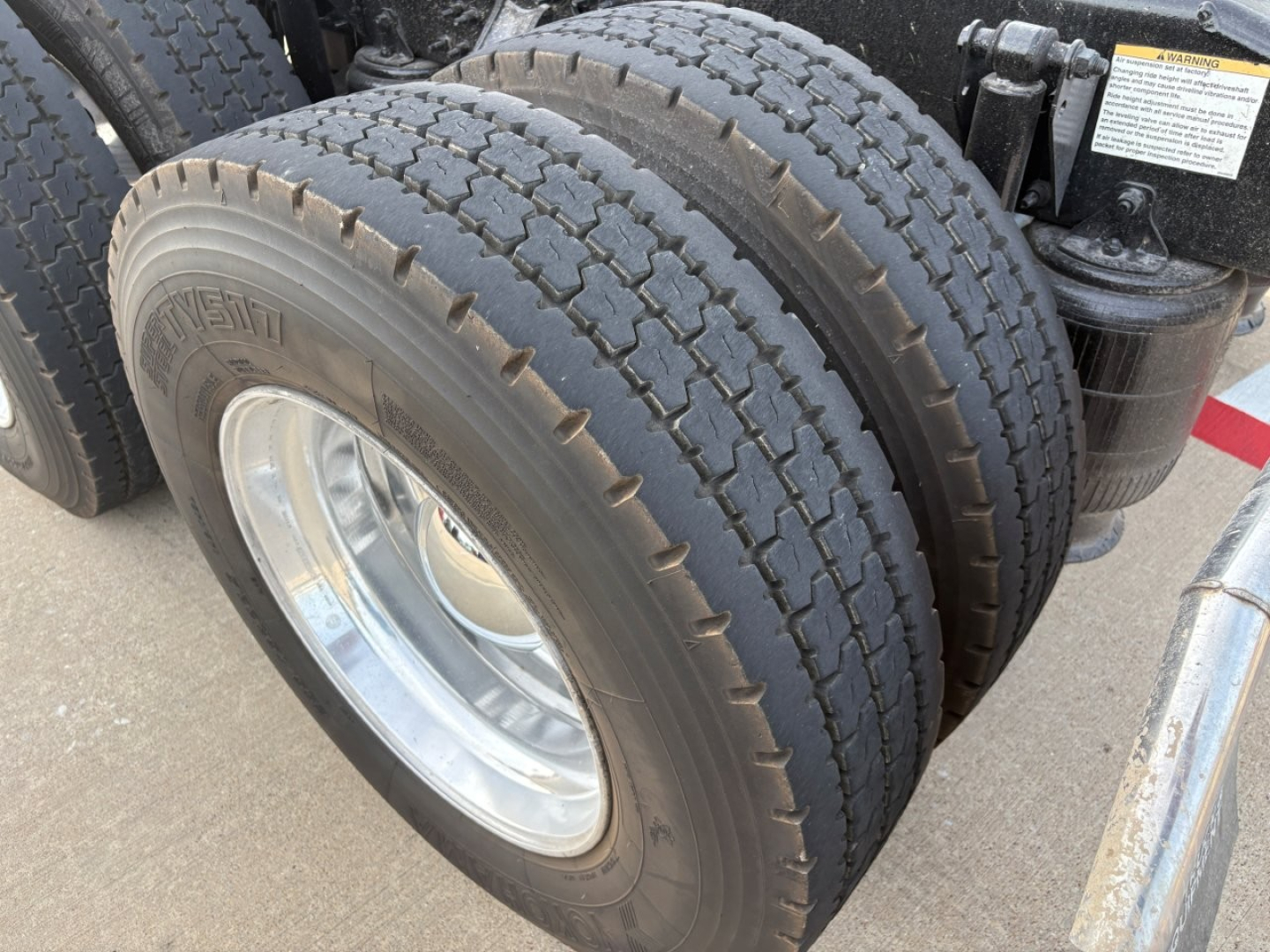 Mack AN64T70 truck axle close-up showing dual rear tires and wheel rims.