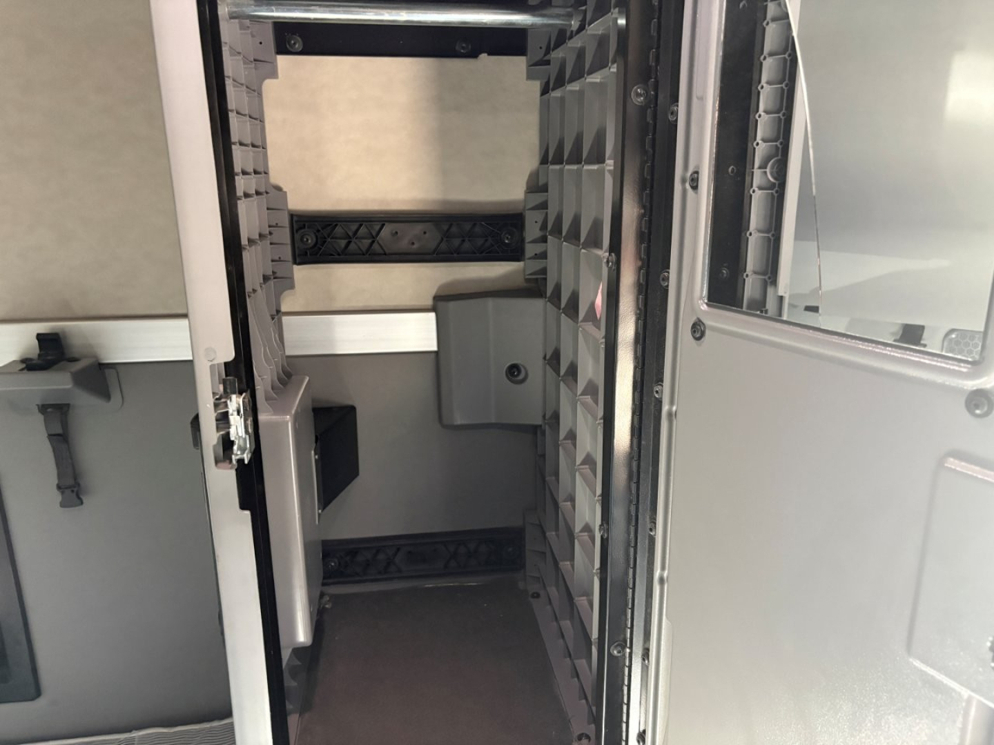 Trucks cab interior showing storage compartments and structural panels in a Mack AN64T70 sleeper cab with open doorway