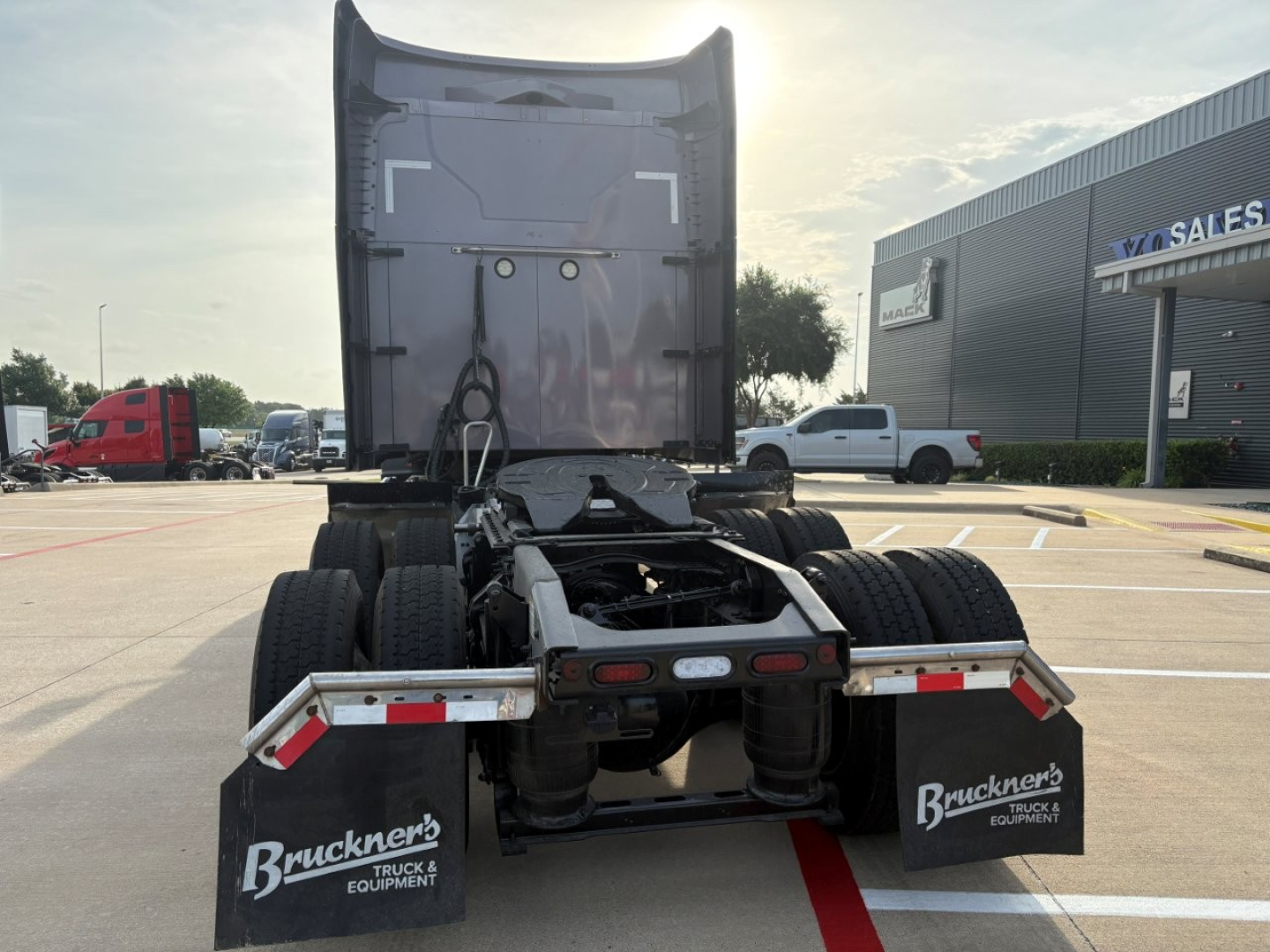 Rear view of a Mack AN64T70 tractor-trailer tractor with fifth wheel and dual rear axles, showing back of cab and mud flaps with Brueckner's Truck & Equipment branding.