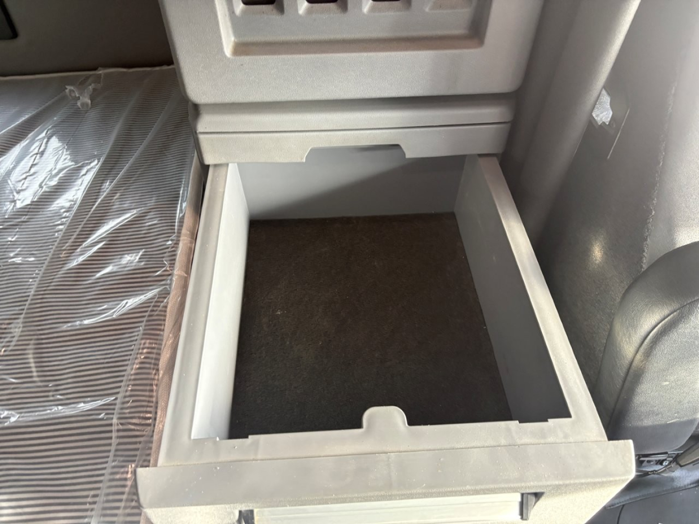Cabinet drawer in Mack AN64T70 sleeper showing empty storage drawer beneath dash.