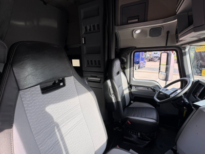 Truck cab interior showing driver seat and steering wheel in a Mack AN64T70 sleeper truck.