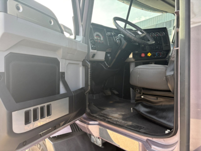 Mack AN64T70 truck cab interior view showing steering wheel, dashboard with gauges, and entry door area.