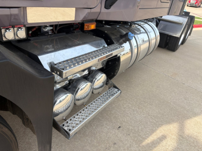 Mack AN64T70 sleeper truck side view showing chrome fuel tanks, aluminum ladder steps, and side access steps with round air tanks beneath.