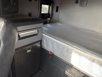 Mack AN64T70 sleeper interior showing aluminum sleeper bed, storage cabinet with drawer, and control panel area.