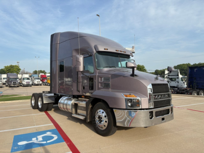 Mack AN64T70 sleeper tractor in a parking lot showing front and side view with chrome bumper and fuel tanks.