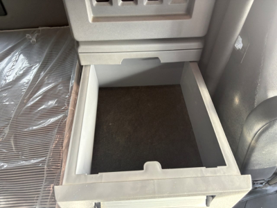 Cabinet drawer in Mack AN64T70 sleeper showing empty storage drawer beneath dash.
