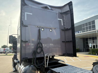 Truck tail with raised bed of a Mack AN64T70 conventional sleeper showing rear doors, hoses, and bumper; no legible text visible.