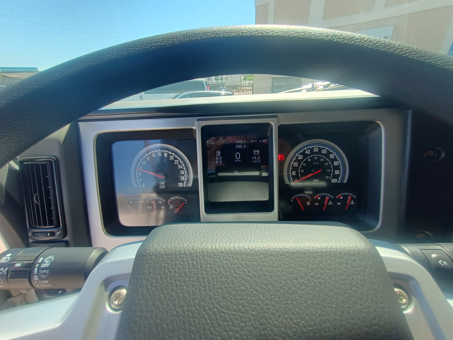 Dashboard view from steering wheel of a 2026 Mack MD7 truck showing instrument cluster and center display.