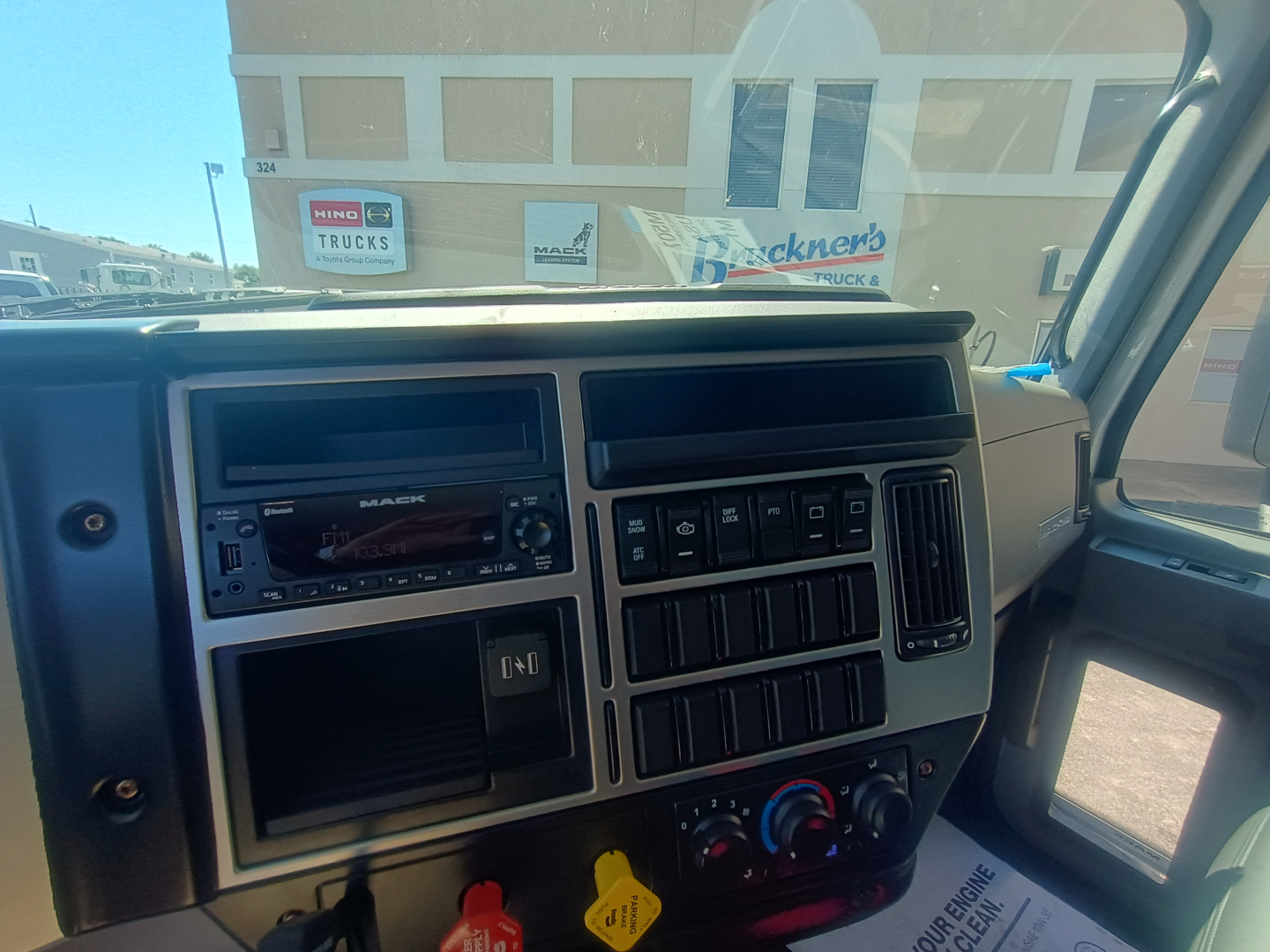 Dashboard view of a 2026 Mack MD7 truck cab showing steering wheel, radio, air vents, and control panel.