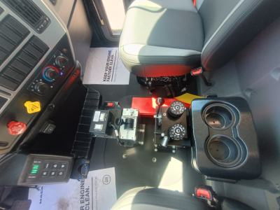 Mack MD7 cab interior showing center control area with two cup holders and gear selector; dashboard controls visible.