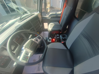 Mack MD7 cab interior showing steering wheel, dashboard, center console with controls, and driver seat.
