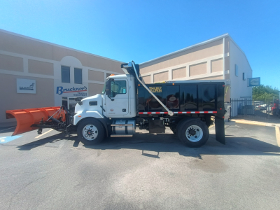 Truck with plow and dump body showing Mack MD7 cab and plow attachment, side view.