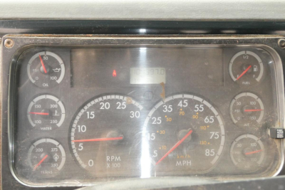 Dashboard gauges of a Freightliner FL70 cab and chassis showing various dials including RPM 0-100, MPH, oil, water, fuel, and air gauges with numeric markers.