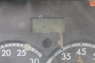 Instrument cluster with speedometer and a small digital display showing numbers behind glare.