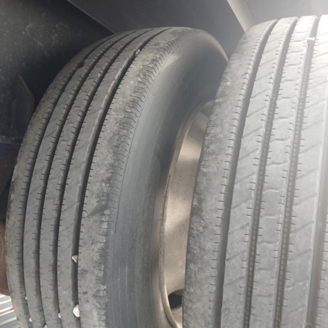 Tandem axle trailer tires with visible treads and rims in close-up view.