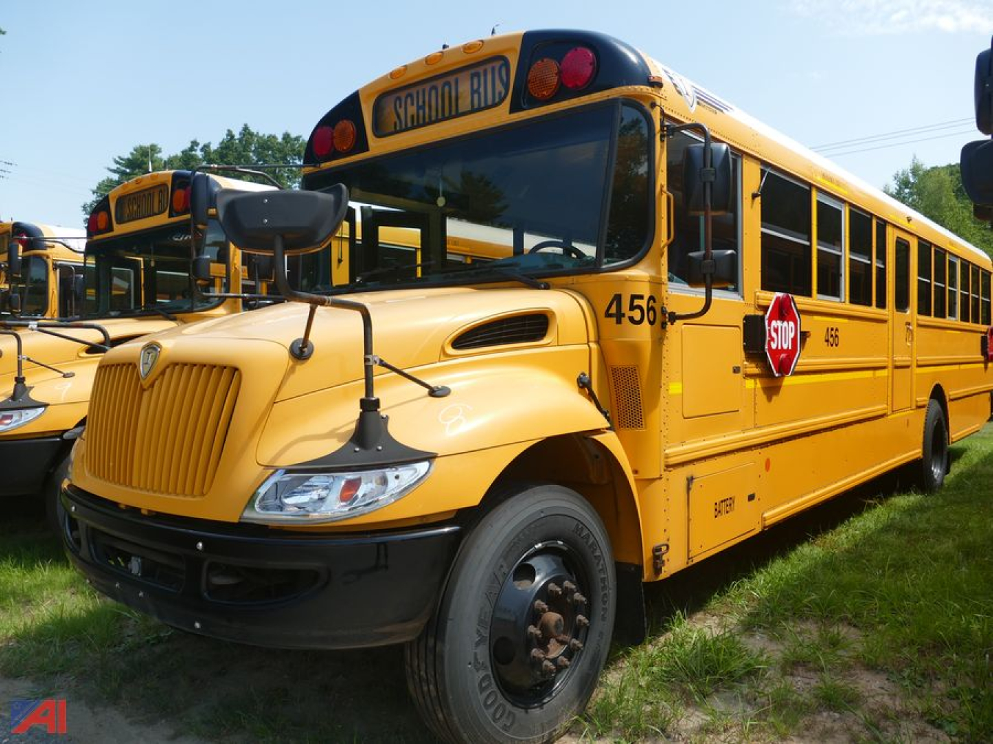 Yellow school bus from side/front angle showing 'SCHOOL BUS' sign, stop sign, rear wheels, and bus number 456 on the front fender.