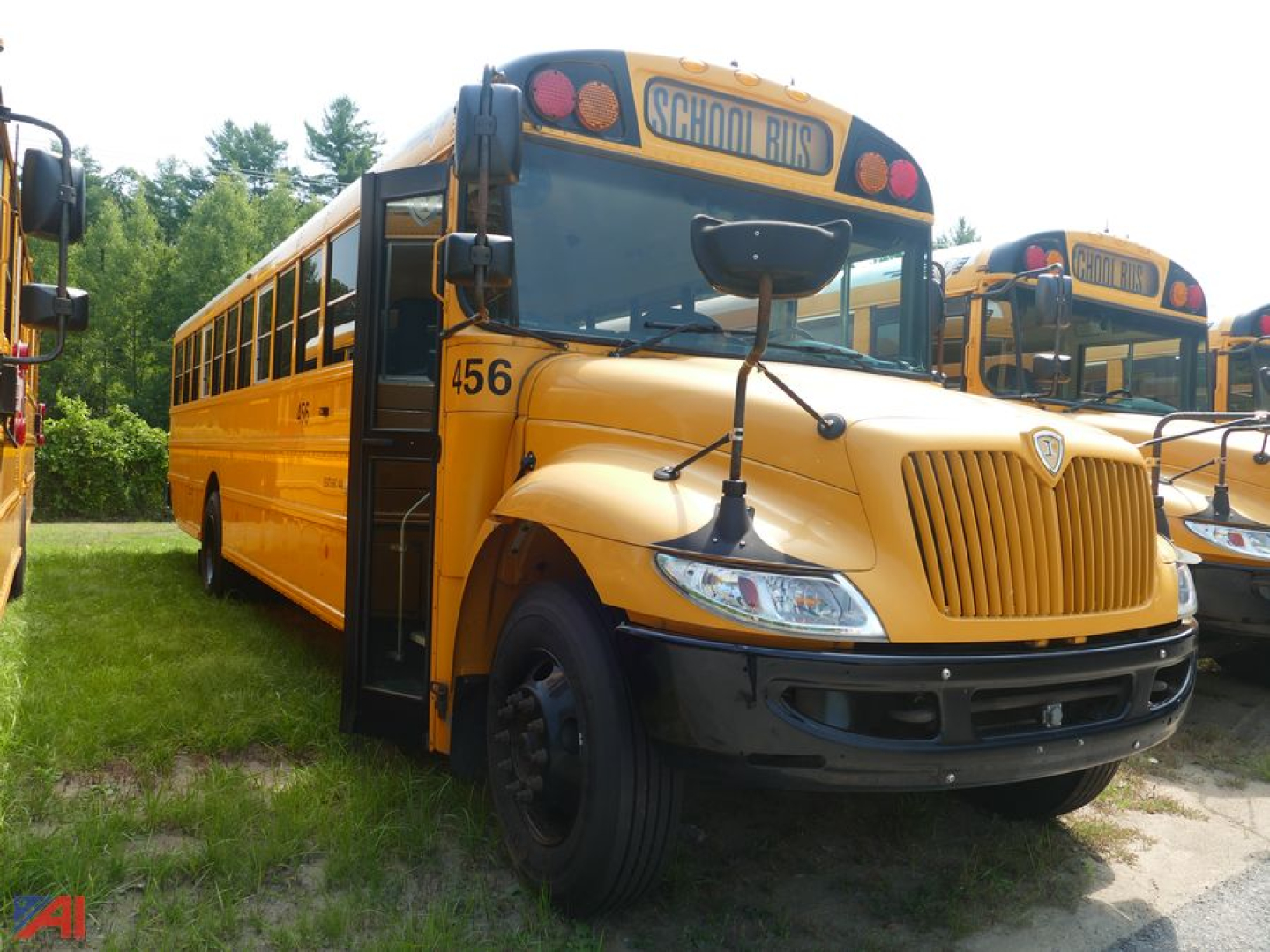 School bus showing front and left side, yellow body with black bumper, 'SCHOOL BUS' sign on top, number 456 on hood, grille, and round headlights.