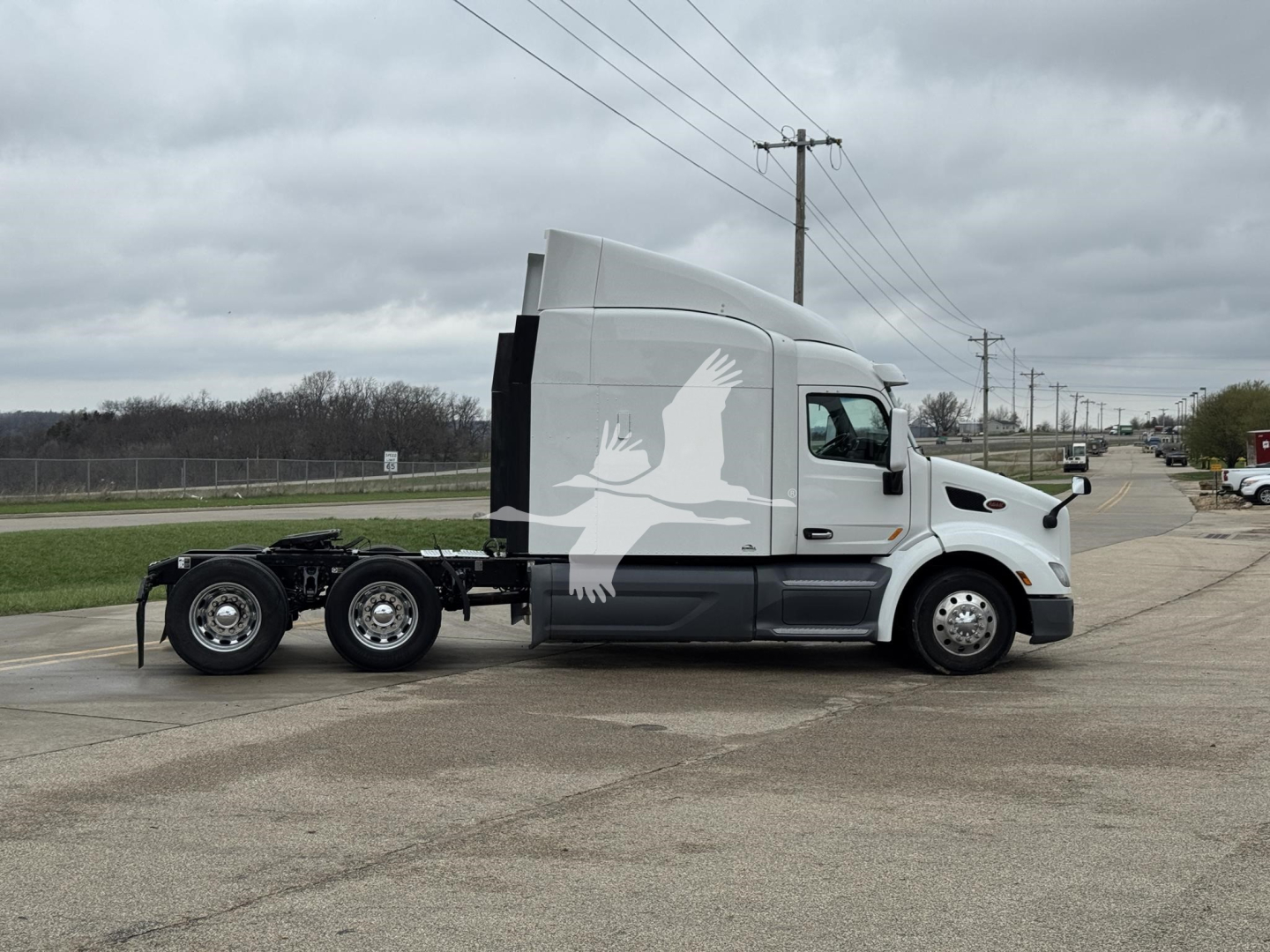 Peterbilt 579 truck tractor side view showing sleeper cab and chassis with logo watermarked across image.
