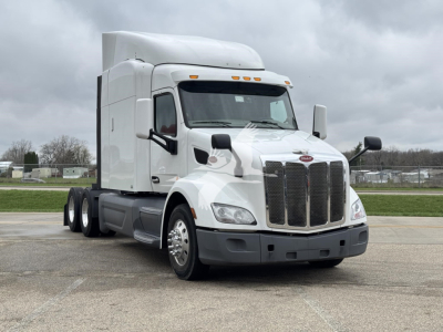 Peterbilt 579 conventional sleeper truck in white, front-left view, with tall sleeper cab and dual rear axles.