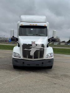Peterbilt 579 front view truck showing grille and hood, white exterior, large mirrors, stock number plate area visible.