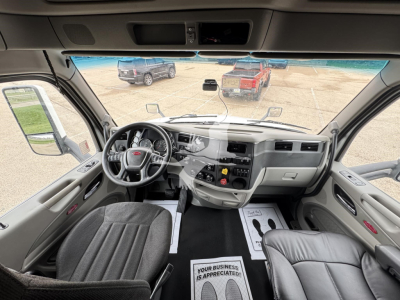 Cab interior of a 2019 Peterbilt 579 in-view from driver seat showing steering wheel, dashboard, center console, and front windows.